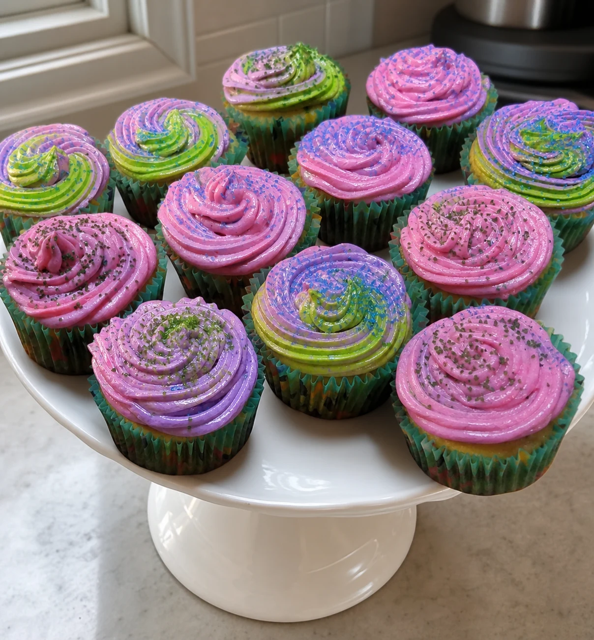 Genevieve’s colorful cupcakes presented on a cake stand